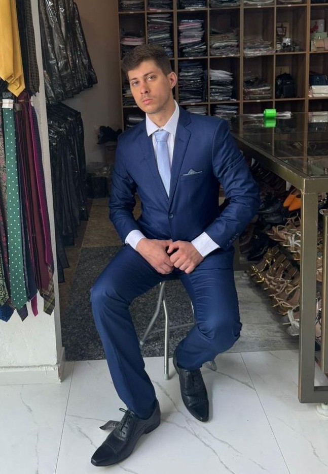 Homem sentado de terno azul